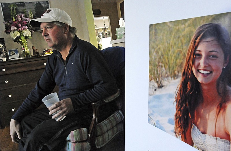 FILE - In this Jan. 23, 2014 file photo, James Holleran, father of Madison Holleran, a University of Pennsylvania freshman who took her own life, talks about his daughter while sitting next to a favorite photo of her at his home in Allendale, N.J. Nearly half of the largest U.S. public universities do not track suicides among their students, despite making investments in prevention at a time of surging demand for mental health services. After her 2014 suicide, one of her former teachers in New Jersey was surprised to learn learn many universities don't report suicide statistics. (April Saul/The Philadelphia Inquirer via AP, File)