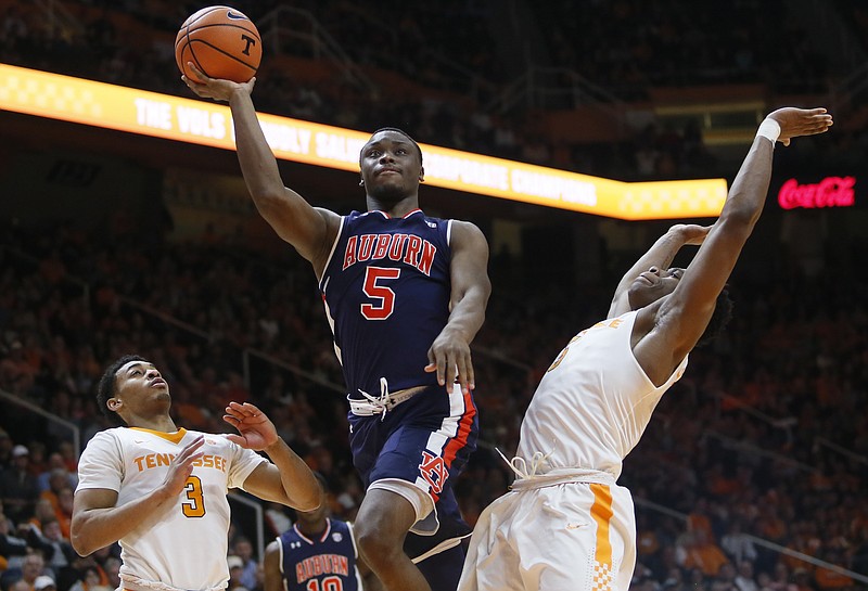 Auburn guard Mustapha Heron (5) is defended under the basket by Tennessee forward Admiral Schofield, right, and Tennessee guard James Daniel III (3) in the second half of an NCAA college basketball game Tuesday, Jan. 2, 2018, in Knoxville, Tenn. Auburn won, 94-84. (AP Photo/Crystal LoGiudice)