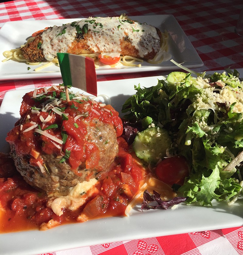 The Bada Bing, Bada Boom, foreground, is an appetizer that is a meal in itself. It's a softball-size, cheese-stuffed meatball topped with red sauce and served with a house salad. In back is the pan-seared, Parmesan-crusted trout, one of the rotating daily specials.