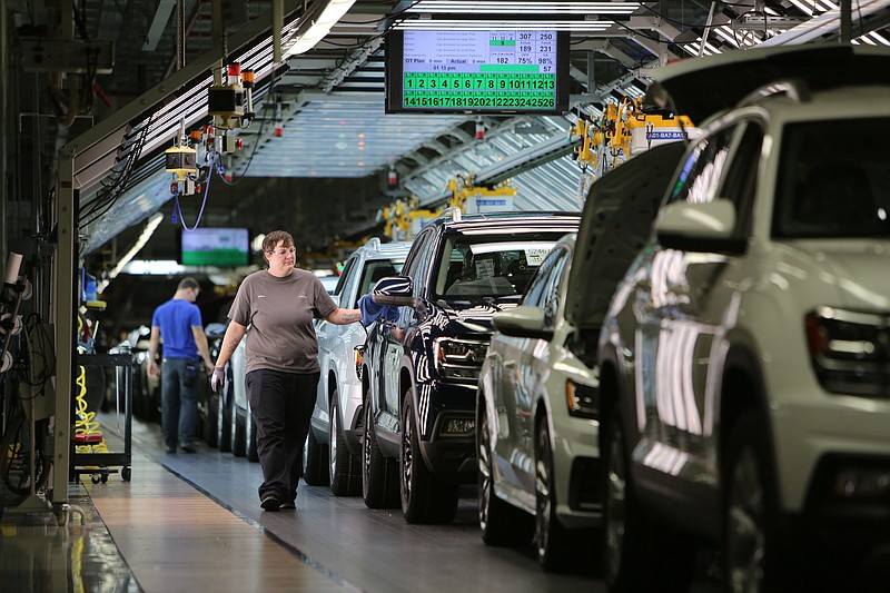 A Volkswagen employee wipes down the sides of cars as they pass her on the assembly line at the Volkswagen Assembly Plant Thursday, Aug. 31, 2017, in Chattanooga, Tenn. In April, VW said there's room in the market for another SUV, a five-seater, that could be a derivative of the Atlas.