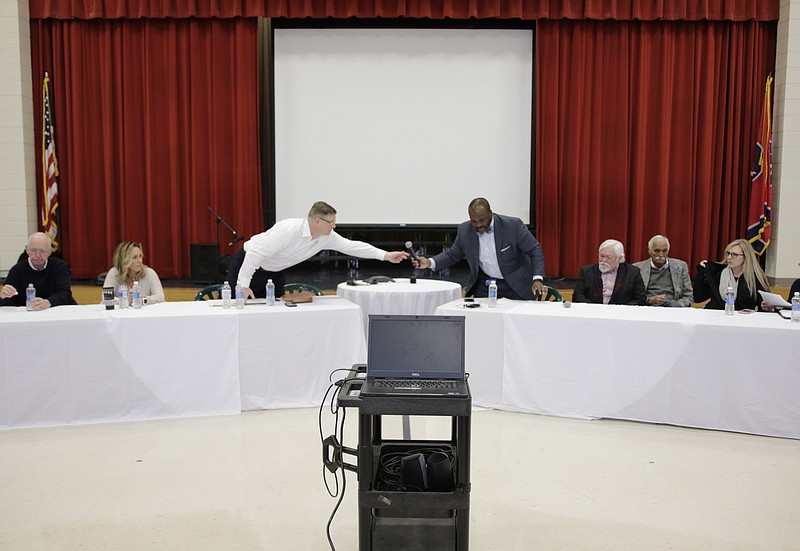 Signal Mountain Mayor Chris Howley hands off a microphone to schools superintendent Bryan Johnson during a meeting between the Signal Mountain Town Council and the Hamilton County Board of Education at Nolan Elementary on Thursday, Jan. 4, 2018, in Signal Mountain, Tenn. Signal Mountain officials and members of the board discussed the town's consideration of splitting from the Hamilton County school system to form their own independent district.