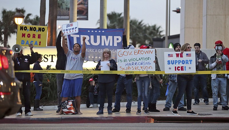 Opponents of demonstrators urging the Democratic Party to protect the Deferred Action for Childhood Arrivals Act (DACA) stand outside the office of California Democratic Sen. Dianne Feinstein in Los Angeles Wednesday, Jan. 3, 2018.