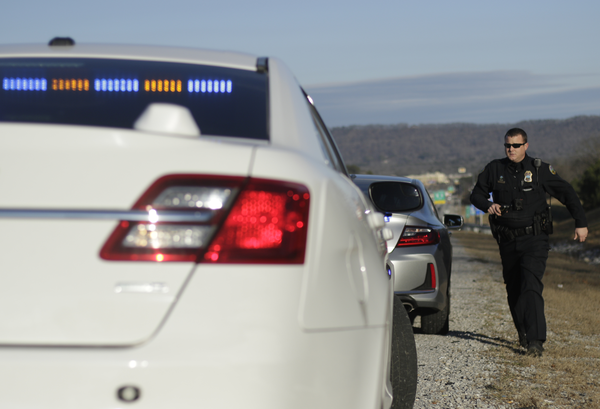 Officer Chris Mullinix returns to his car after giving a speeding citation to a driver on Interstate 75 while on traffic patrol on Friday, Jan. 5, 2018, in Chattanooga, Tenn.