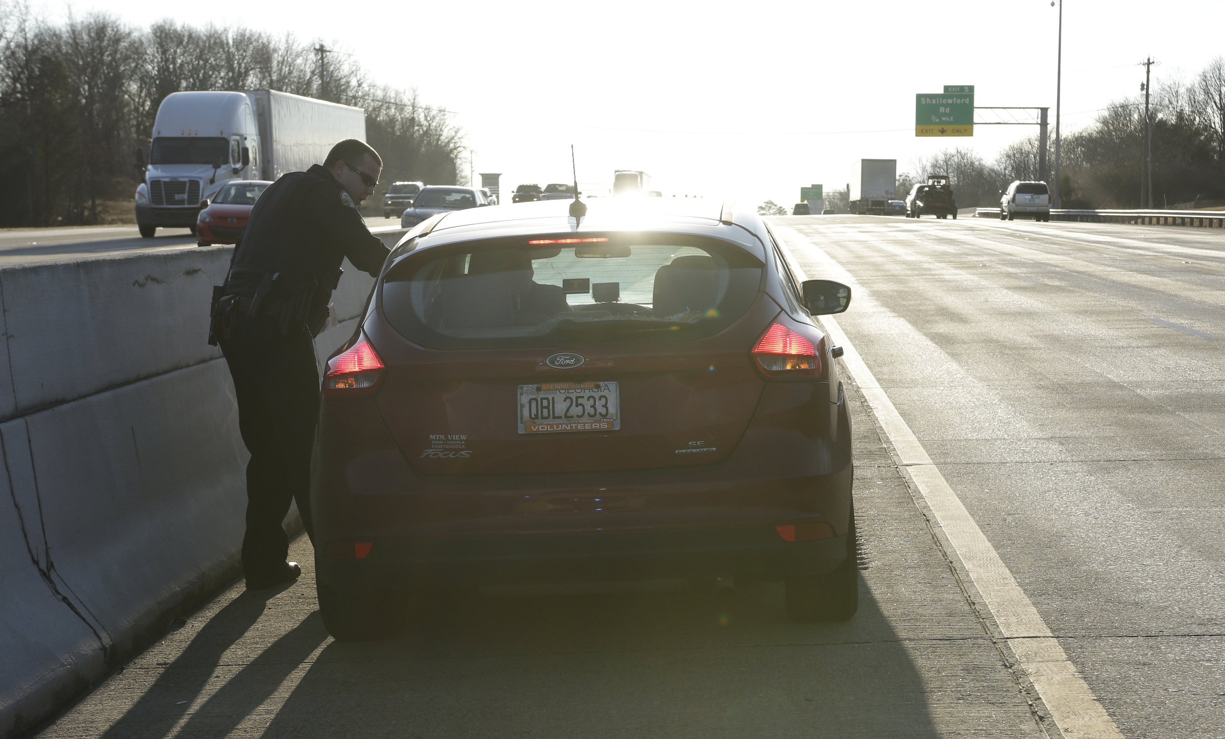 Officer Chris Mullinix cites a speeding offender with an additional offense after they pulled to the center median of Interstate 75 while on traffic patrol on Friday, Jan. 5, 2018, in Chattanooga, Tenn. In Tennessee, pulling to the center median for a police officer is illegal.