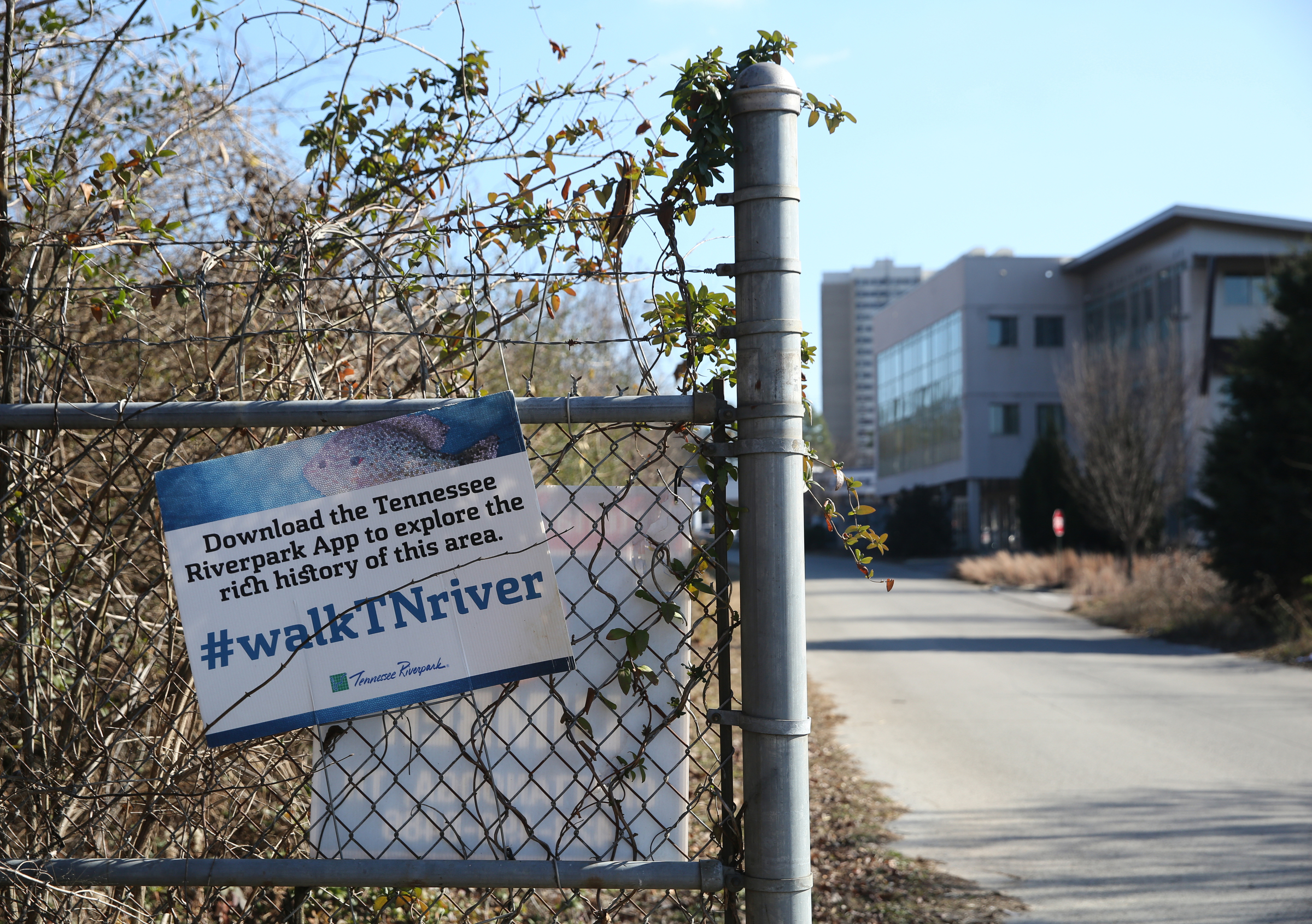 A Tennessee Riverpark sign hangs from the fence alongside West Ninth Street, which currently leads to the Blue Goose Hallow trailhead, Thursday, Jan. 4, 2018 in Chattanooga, Tenn. An expansion is planned for M.L. King Boulevard that will cross Riverfront Parkway to the Blue Goose Hallow trailhead, which will take the place of West Ninth Street.