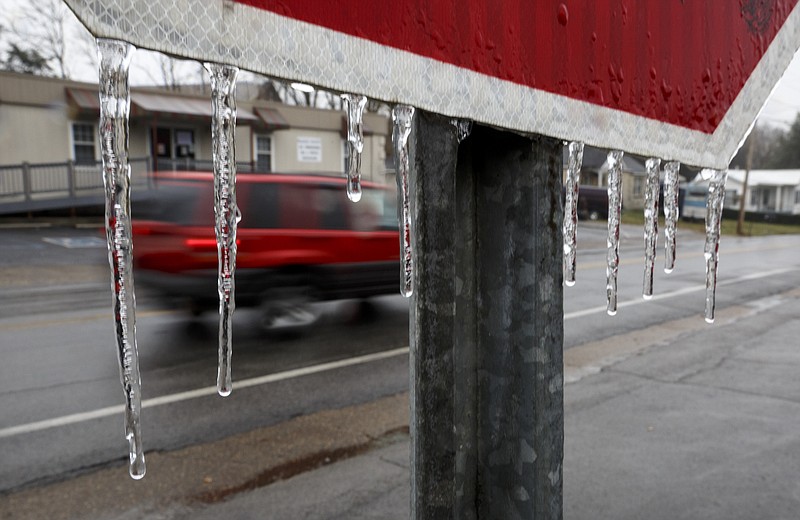 Icicles hang from a stop sign on Reece Street after a wintry mix of snow and ice swept through the region Wednesday, Jan. 20, 2016, in Rossville, Ga. The winter weather caused traffic collisions and delays on roads across the area.