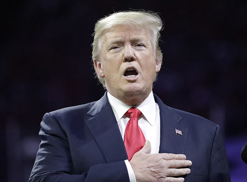 President Donald Trump sings the national anthem before the NCAA college football playoff championship game between Georgia and the AlabamaMonday, Jan. 8, 2018, in Atlanta. (AP Photo/David J. Phillip)