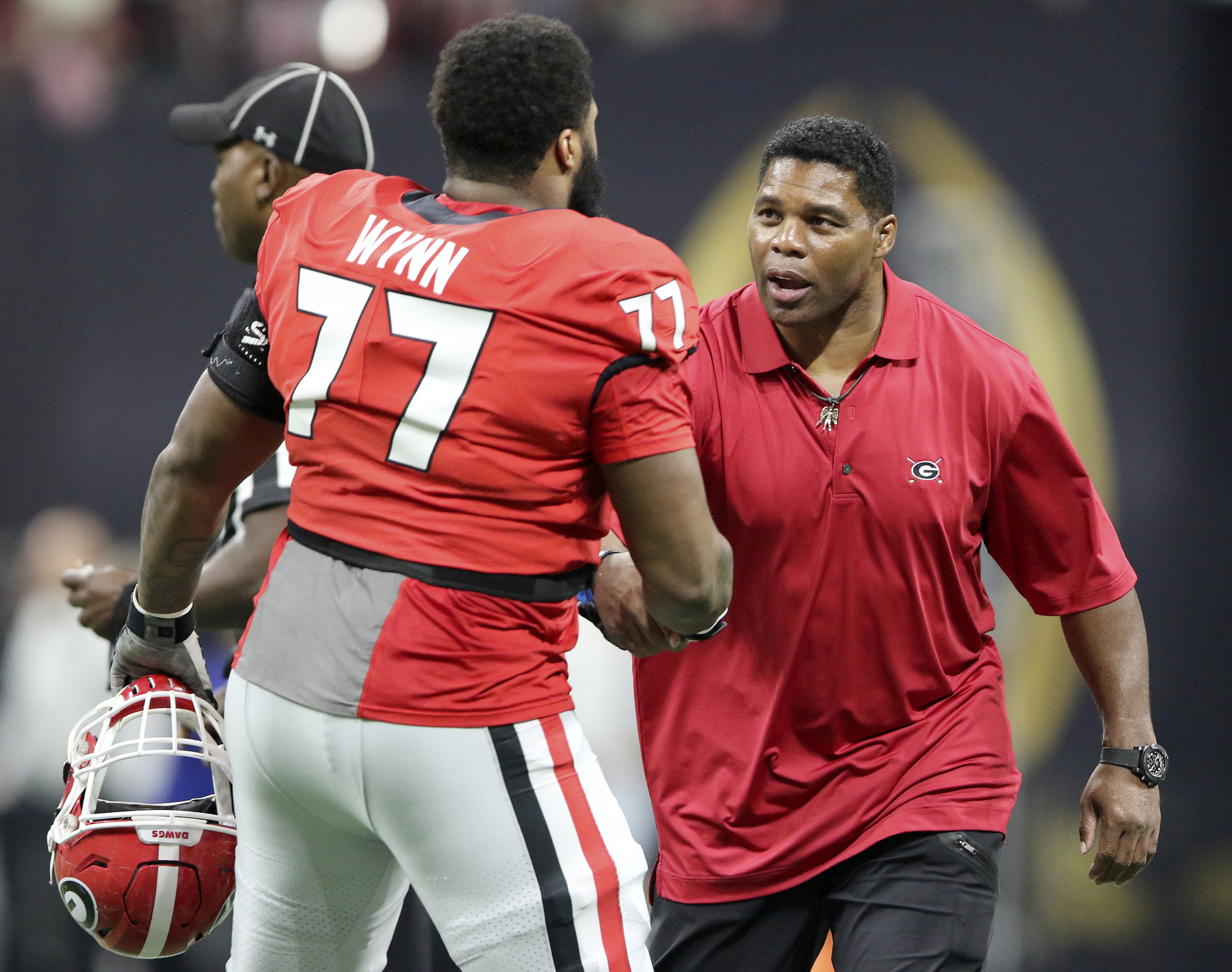 Former Georgia great Herschel Walker, right, greets Georgia offensive lineman Isaiah Wynn (77) after the coin toss prior to the College Football Playoff national championship against Alabama at Mercedes-Benz Stadium on Monday, Jan. 8, 2018 in Atlanta, Ga.