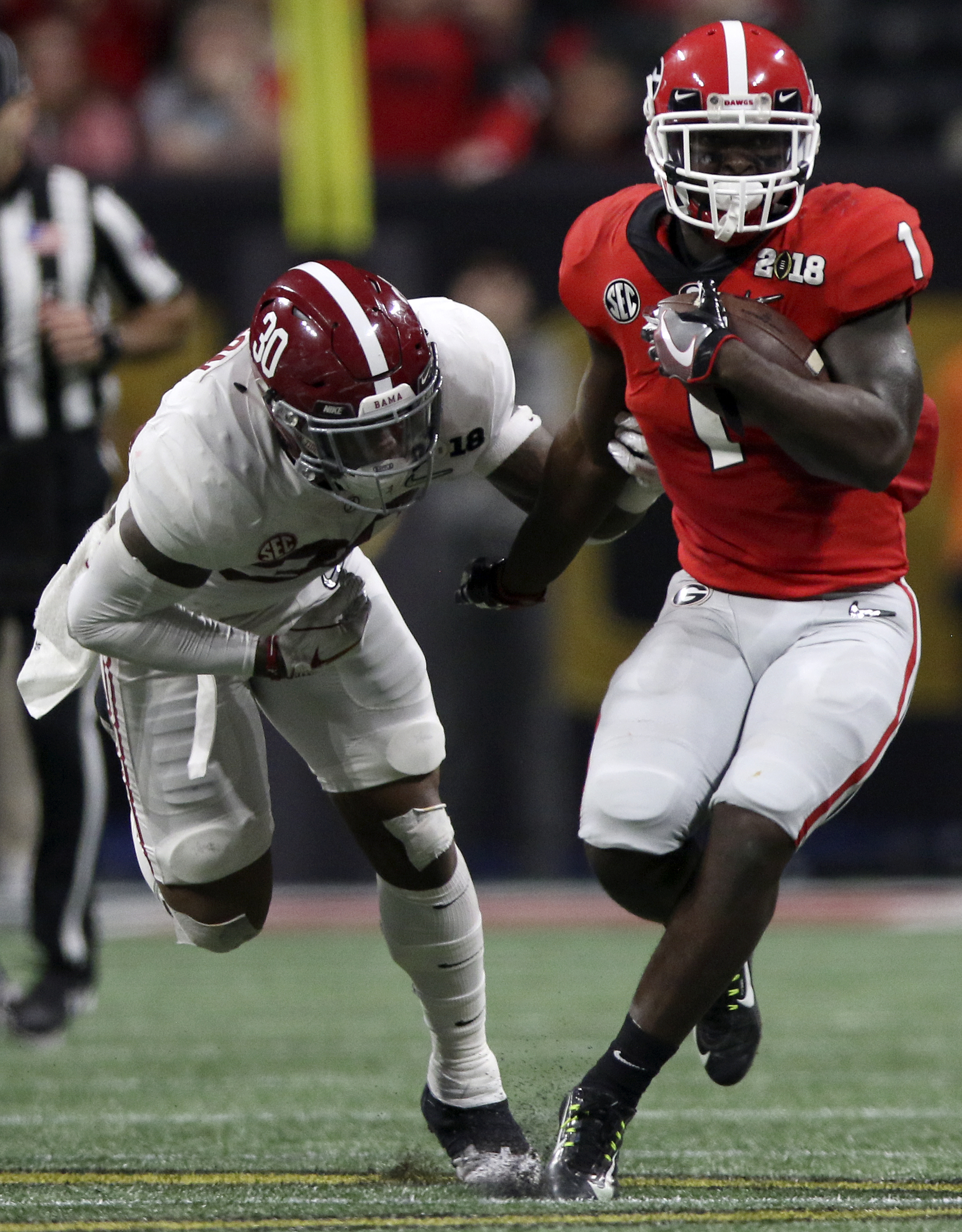 Alabama linebacker Mack Wilson (30) reaches for the arm of Georgia running back Sony Michel (1) as he rushes for a 14-yard gain during the College Football Playoff national championship at Mercedes-Benz Stadium on Monday, Jan. 8, 2018 in Atlanta, Ga.