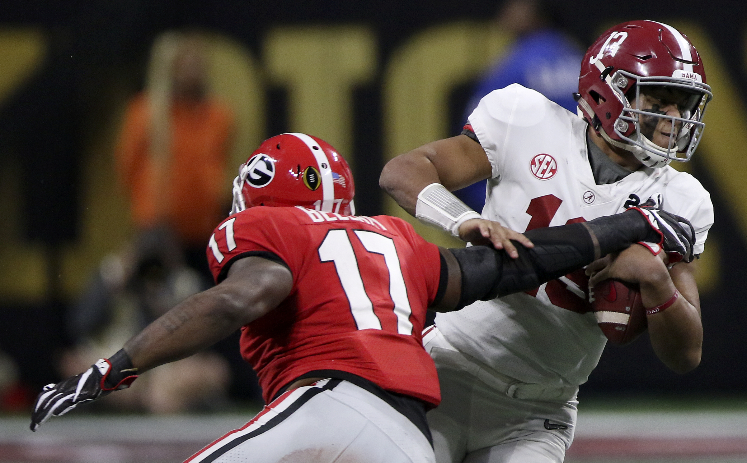 Alabama quarterback Tua Tagovailoa (13) evades a tackle attempt from Georgia linebacker Davin Bellamy (17) as he picks up nine yards College Football Playoff national championship at Mercedes-Benz Stadium on Monday, Jan. 8, 2018 in Atlanta, Ga.
