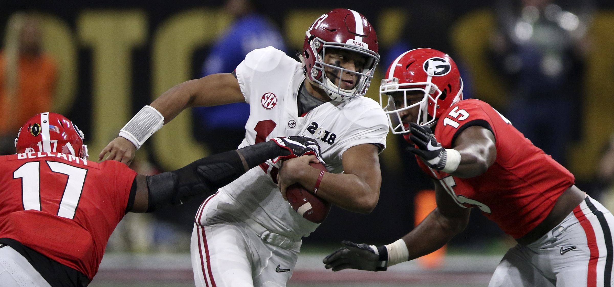 Alabama quarterback Tua Tagovailoa (13) evades Georgia linebackers Davin Bellamy (17) and D'Andre Walker (15) as he scrambles for a 9-yard gain during the College Football Playoff national championship at Mercedes-Benz Stadium on Monday, Jan. 8, 2018 in Atlanta, Ga.