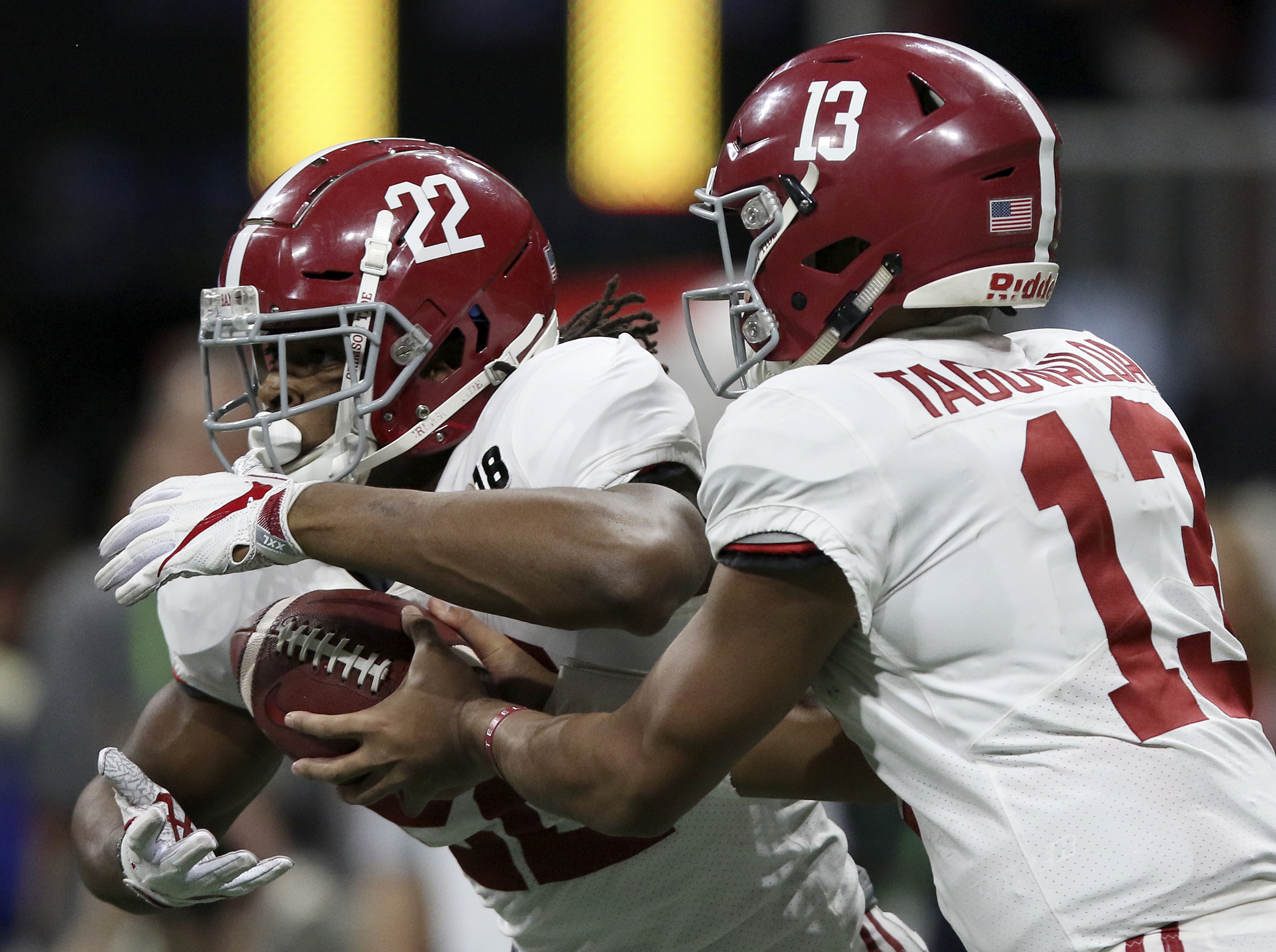 Alabama quarterback Tua Tagovailoa (13) hands the ball off to running back Najee Harris (22), who would rush for 16-yard gain, during the College Football Playoff national championship against Georgia at Mercedes-Benz Stadium on Monday, Jan. 8, 2018 in Atlanta, Ga.