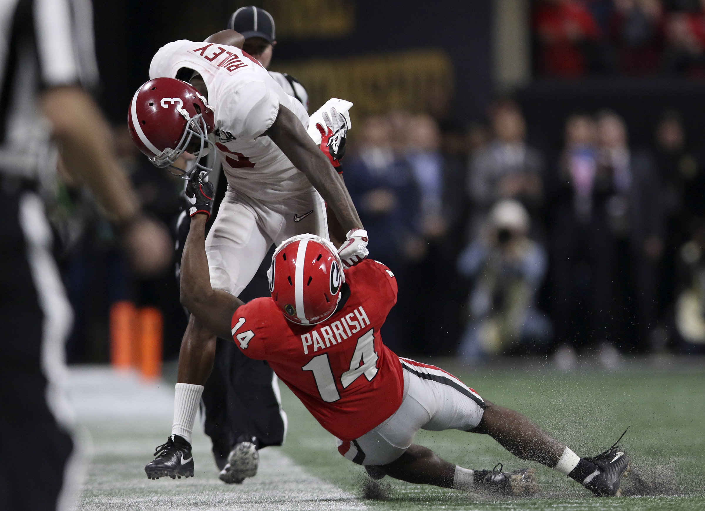 Georgia defensive back Malkom Parrish (14) grabs the face mask of Alabama wide receiver Calvin Ridley (3) as he forces Ridley out-of-bounds for a 9-yard gain during the College Football Playoff national championship at Mercedes-Benz Stadium on Monday, Jan. 8, 2018 in Atlanta, Ga. The face mask penalty would add an additional 15 yards to Ridley's gain.