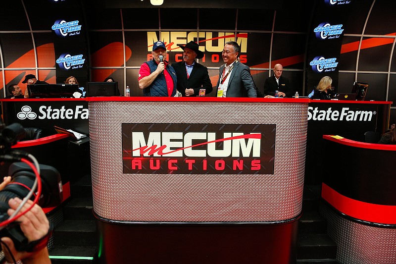 Dana Mecum, president of Mecum Auctions, left, talks with Coker Tires owner Corky Coker, center, and President Wade Kawasaki during an NBCSN broadcast from Kissimmee, Fla.