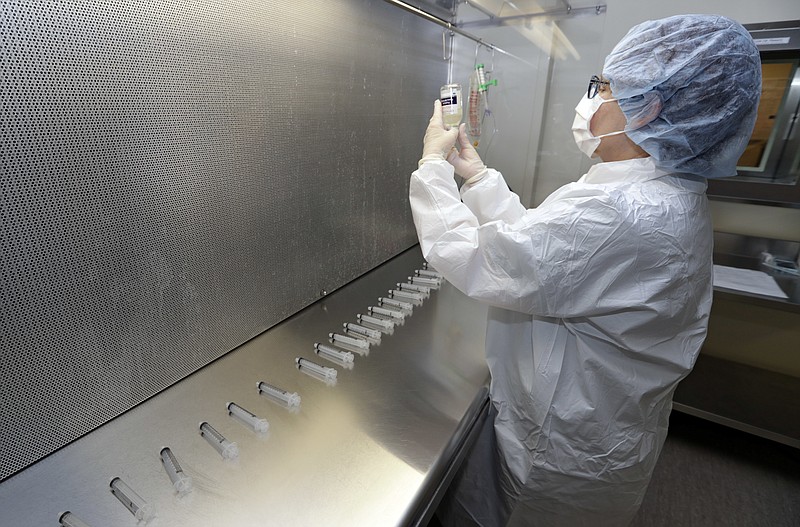 In this Monday, Jan. 8, 2018, photo, certified pharmacy technician Peggy Gillespie compounds antibiotics to fill into syringes for use as an I.V. push at ProMedica Toledo Hospital in Toledo, Ohio.