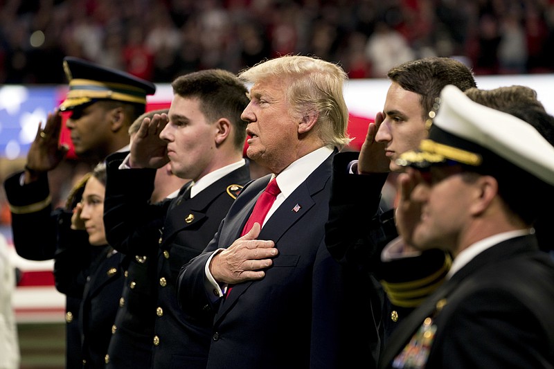 President Donald Trump stands on the field for the National Anthem before the start of the NCAA National Championship game at Mercedes-Benz Stadium between Georgia and Alabama, Monday, Jan. 8, 2018, in Atlanta. (AP Photo/Andrew Harnik)