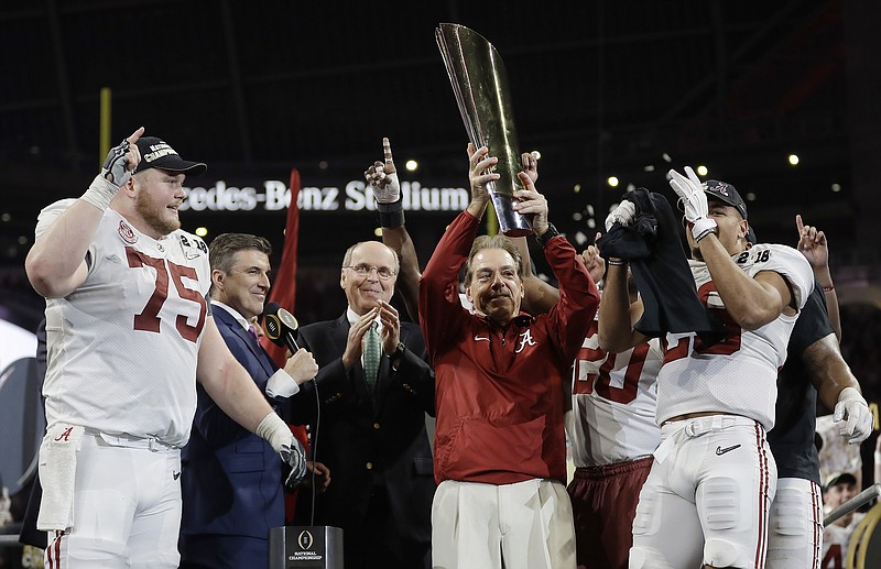 Alabama head coach Nick Saban holds up the championship trophy after overtime of the NCAA college football playoff championship game against Georgia, Monday, Jan. 8, 2018, in Atlanta. Alabama won 26-23. (AP Photo/David J. Phillip)
