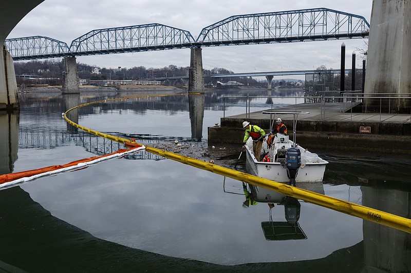 Workers with the HEPACO emergency response company remove debris from an oil containment boom at Ross's Landing on Wednesday, Jan. 10, 2018, in Chattanooga, Tenn. TDEC continues to investigate a fuel spill of more than 1,000 gallons from Norfolk Southern Railway's deButts Yard into Citico Creek, which feeds into the Tennessee River.