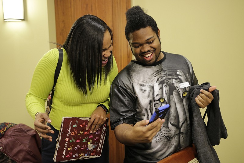 Miles College freshman Marshun Burgess shows project coordinator Shamira Freeman a video of his cheerleading at a check-in for students from the GEAR UP college readiness program at the University of Tennessee at Chattanooga on Thursday, Jan. 4, 2018, in Chattanooga, Tenn. GEAR UP begins academic counseling and a support system for underserved students as early as 6th grade.