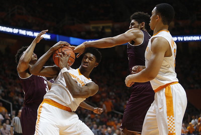 Tennessee forward Kyle Alexander, center, fights for the ball between Texas A&M center Tyler Davis, second on right, and Texas A&M guard Admon Gilder, left, beside Tennessee forward Grant Williams, far right, in the first half of an NCAA college basketball game Saturday, Jan. 13, 2018, in Knoxville, Tenn. (AP Photo/Crystal LoGiudice)