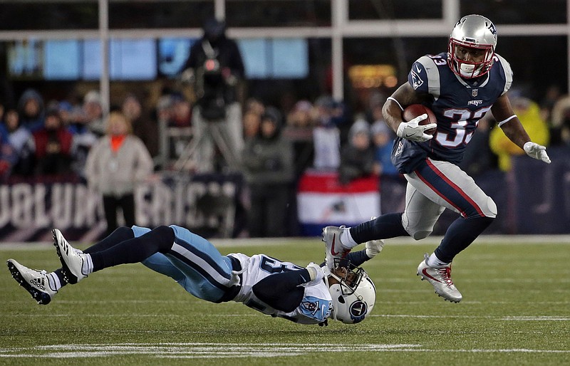 New England Patriots running back Dion Lewis, right, eludes Tennessee Titans cornerback Tye Smith during the first half of an NFL divisional playoff football game, Saturday, Jan. 13, 2018, in Foxborough, Mass. (AP Photo/Steven Senne)