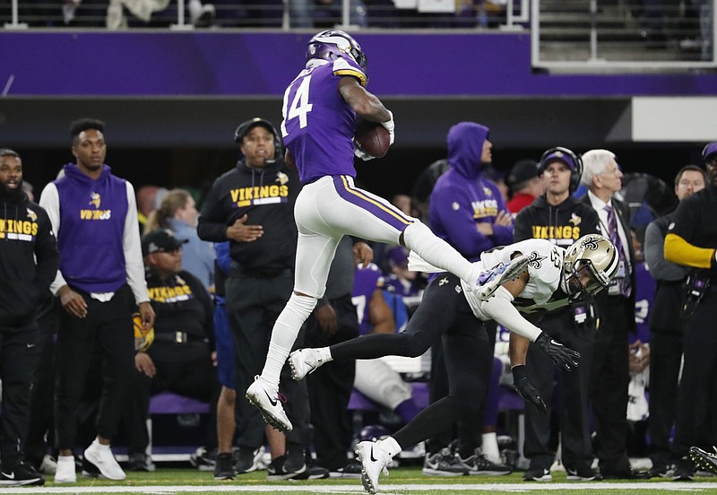Minnesota Vikings wide receiver Stefon Diggs (14) makes a catch over New Orleans Saints free safety Marcus Williams on his way to the game-winning touchdown during the second half of a divisional round playoff game Sunday in Minneapolis. The Vikings won 29-24.