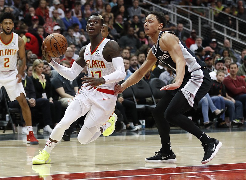 Atlanta Hawks guard Dennis Schroder (17) drives past San Antonio Spurs forward Kyle Anderson (1) as he goes to the basket in the second half of an NBA basketball game Monday, Jan. 15, 2018, in Atlanta. The Hawks won 102-99. (AP Photo/John Bazemore