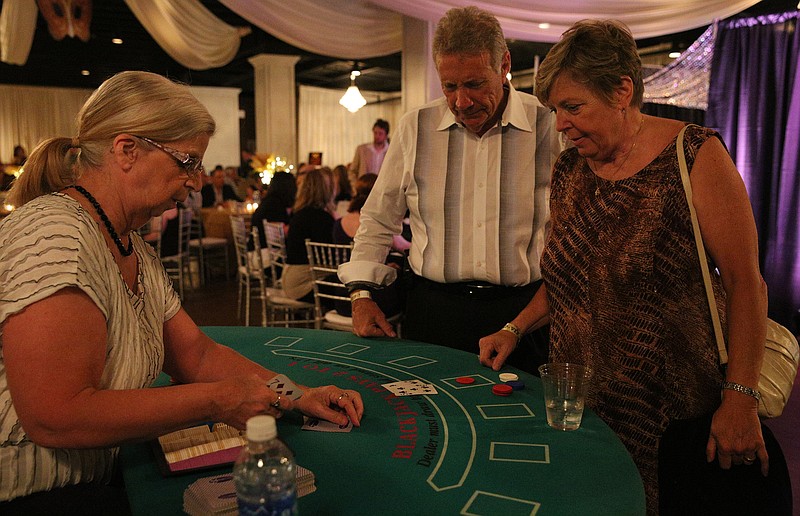 In this 2014 staff file photo, Anne Jay lays out cards as Tom and Sue Kral play blackjack at the masquerade benefit for Children's Advocacy Center at Stratton Hall.