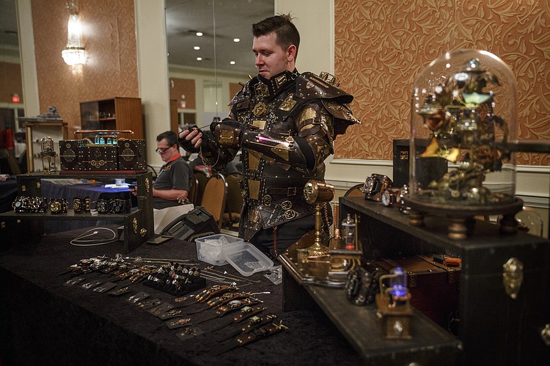 Above, James Neathery of Nashville wears a suit of steampunk armor as he sets up his vendor's booth at Chattacon 42. His company, Starboard Sky Industries, will be among vendors at this weekend's Chattacon 43. 
At left, Bill Harrison talks about some of his custom made toy steampunk weapons at Chattacon 42.
