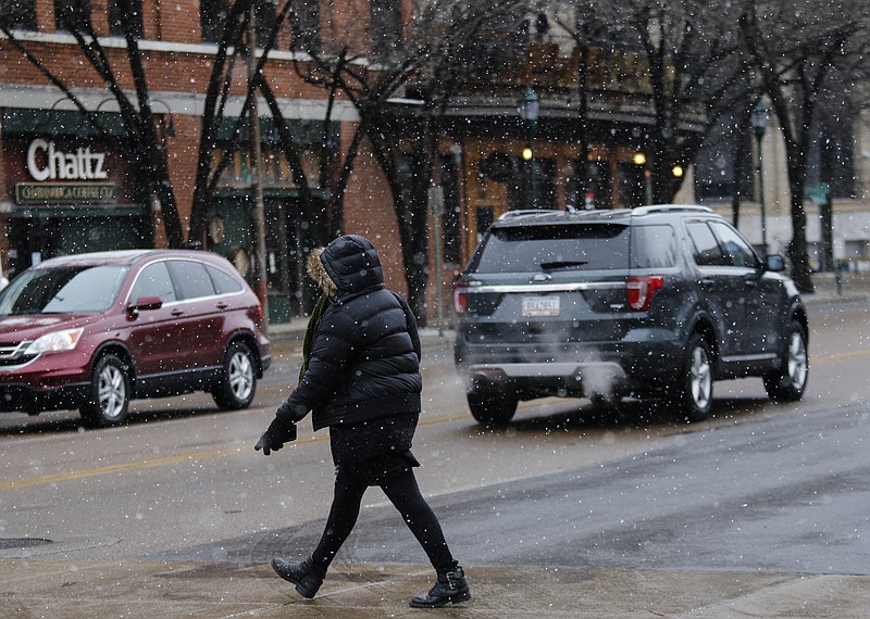 A pedestrian crosses Market Street in the snow downtown on Tuesday, Jan. 16, 2018, in Chattanooga, Tenn. A winter storm brought snow, ice and frigid temperatures to the region and much of the Southeast on Tuesday.