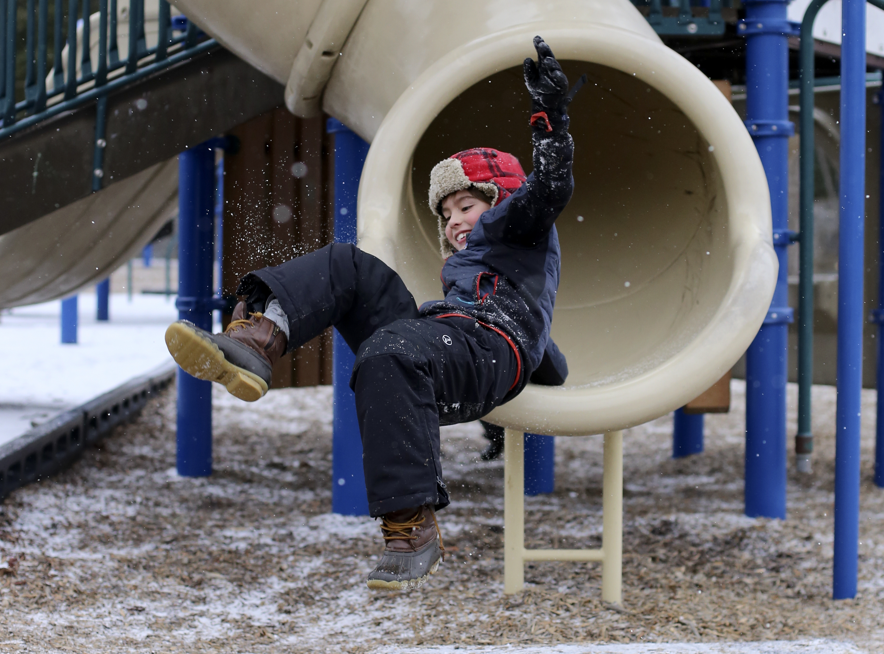 Seven-year-old Holden Royal catches air as he exits a slide at Riverview Park on Tuesday, Jan. 16, 2018 in Chattanooga, Tenn. Chattanooga experienced a light dusting of snow by late afternoon. The fear of inclement weather closed several area schools.