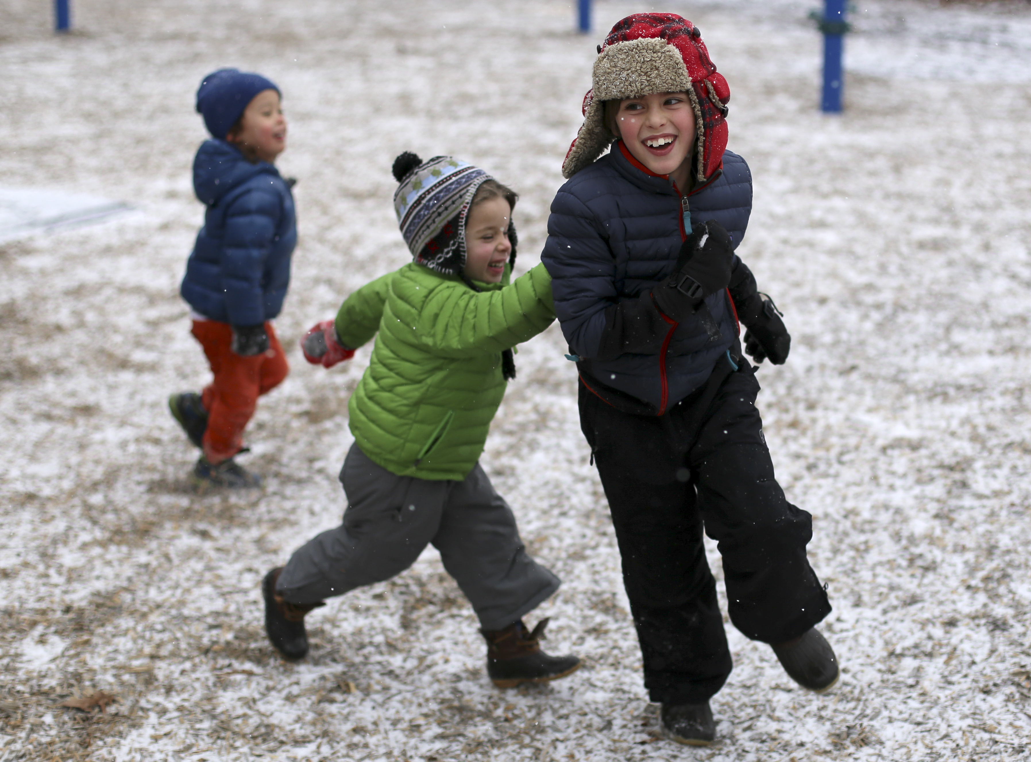 Five-year-old Charlie Royal, center, chases his brother Holden Royal, 7, while playing at Riverview Park on Tuesday, Jan. 16, 2018 in Chattanooga, Tenn. Chattanooga experienced a light dusting of snow by late afternoon. The fear of inclement weather closed several area schools.