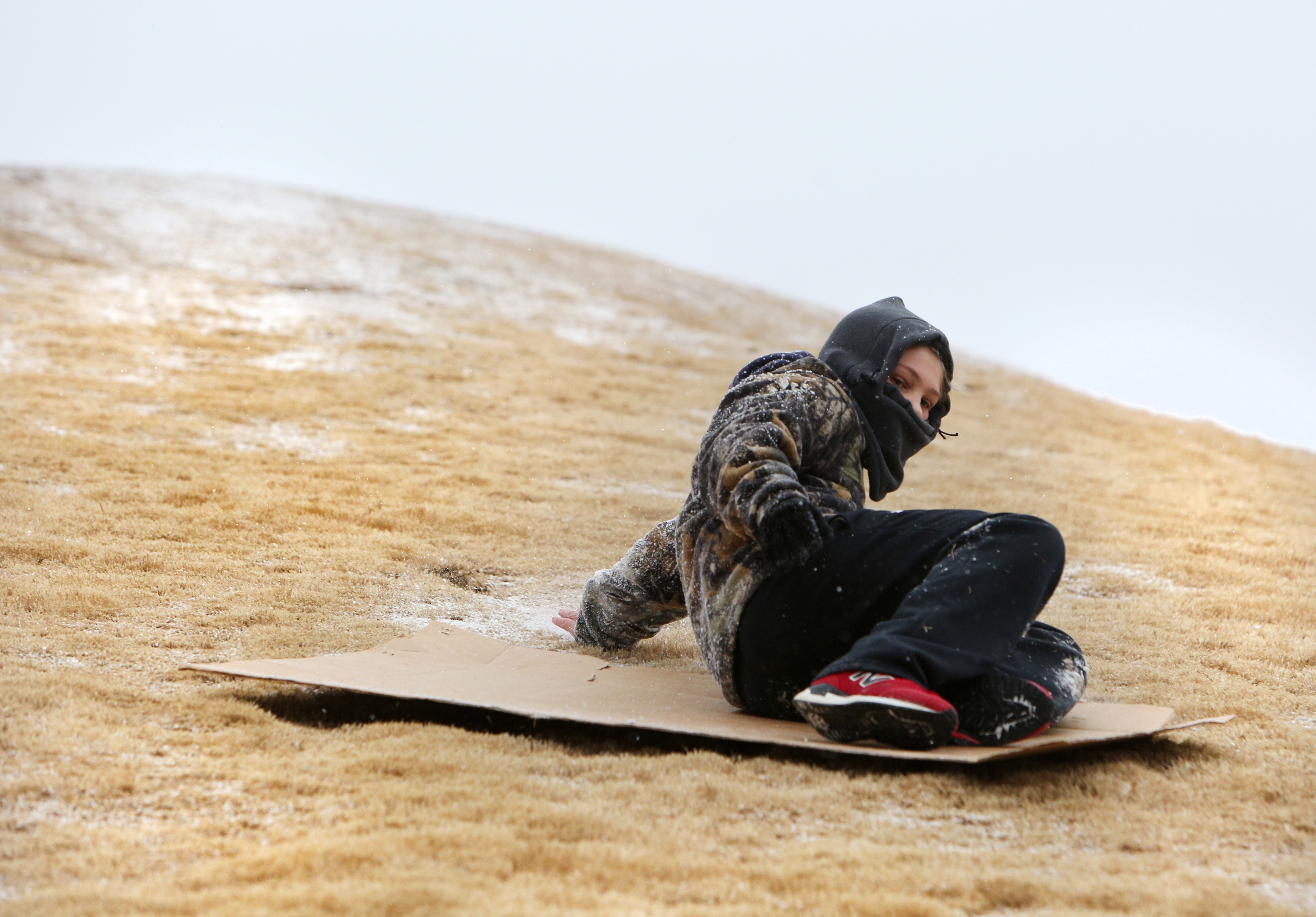 Will Reason, 10, slides down a hill in Renaissance Park on a cardboard box Tuesday, Jan. 16, 2018 in Chattanooga, Tenn. Reason and his family moved to a condo beside Renaissance Park less than a week ago and decided to take advantage of the light snow the Chattanooga received Tuesday evening.
