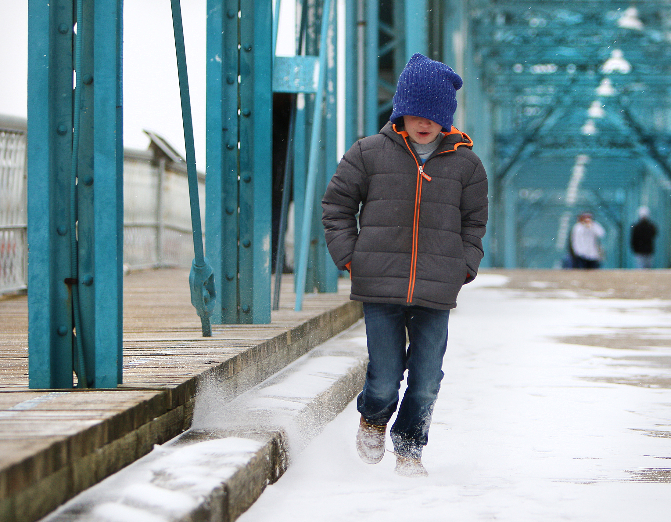 Cason O'Connor, 8, kicks up snow as he walks on Walnut Street Bridge Tuesday, Jan. 16, 2018 in Chattanooga, Tenn. Cason and his family decided to venture out of their house Tuesday evening when they saw the snow had begun to accumulate.