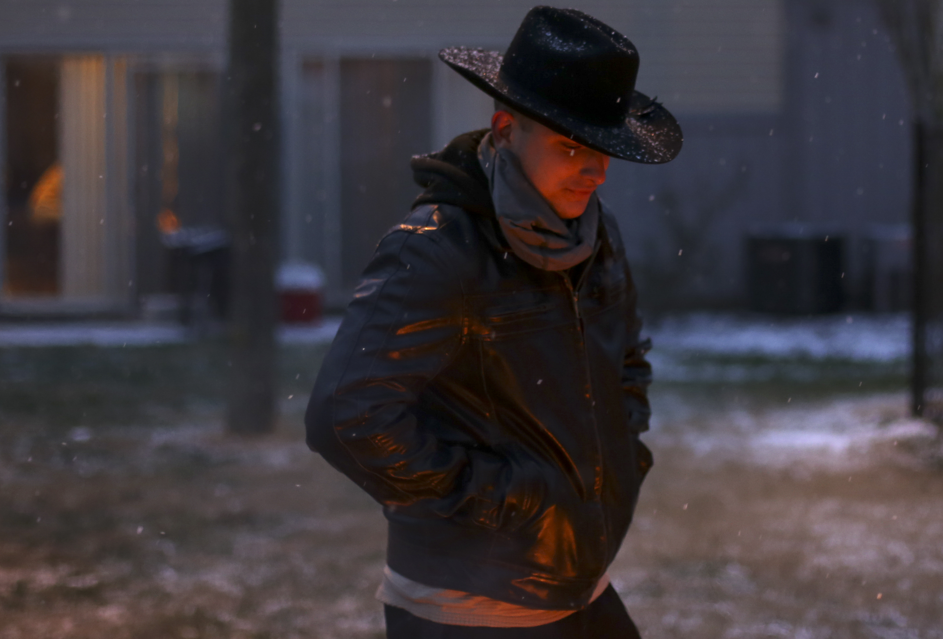 As snow falls, Hayden Compton stands near a fire at the Northshore Village apartments on Tuesday, Jan. 16, 2018 in Chattanooga, Tenn. Chattanooga experienced a light dusting of snow by late afternoon.