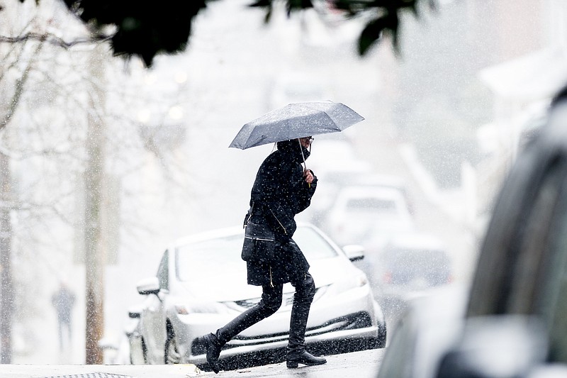 A woman walks through Fort Sanders during an afternoon snowfall in Knoxville, Tenn., Tuesday, Jan. 16, 2018. (Calvin Mattheis/Knoxville News Sentinel via AP)