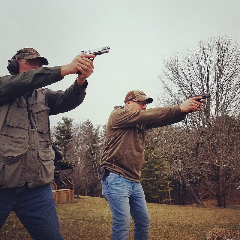 Outdoors columnist Larry Case, left, fires a 1911-style pistol while Woodrow Brogan shoots a Glock. The debate about which is the superior firearm is a well-worn topic in the world of guns, writes Case.