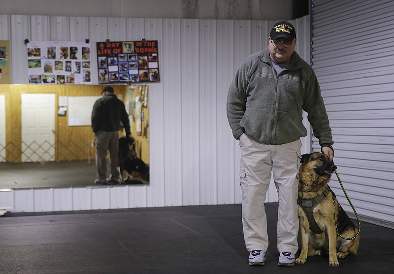 Veteran Scott Mincey stands with his service dog, Sasha, at a planning meeting for Operation Freedom Dogs at the Chattanooga Obedience Club in Flintstone, Ga. Operation Freedom Dogs is a nonprofit that teaches veterans to train rescued service dogs.