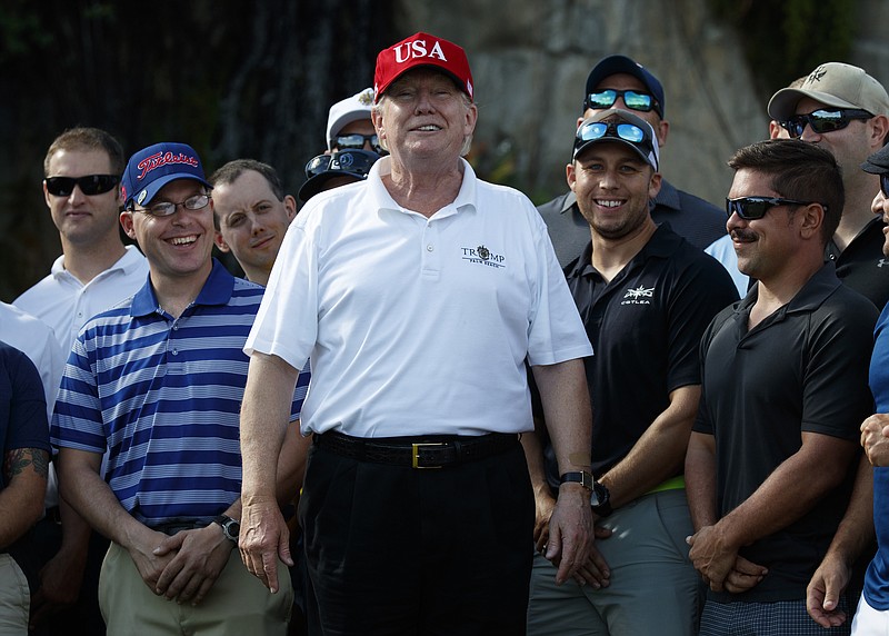 President Donald Trump shares a laugh with members of the U.S. Coast Guard, who he invited to play golf, at Trump International Golf Club in West Palm Beach, Fla., in December.