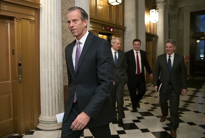 FILE - In this Dec. 18, 2017, file photo, Sen. John Thune, R-S.D., heads to a meeting at the Capitol in Washington. Key senators and farm groups are trying to fix a provision in the federal tax overhaul that gave an unexpected tax break to farmers who sell their crops to cooperatives instead of private buyers. The provision from Thune and John Hoeven, R-N.D., surfaced in the final days of the debate over the tax bill, which President Donald Trump signed last month. (AP Photo/J. Scott Applewhite, File)