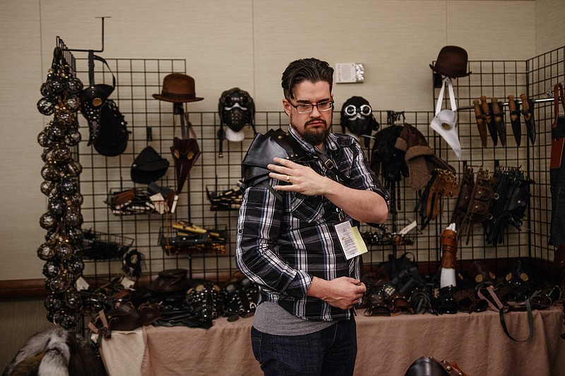 Artist guest of honor Sam Flegal tries on a leather armor peice from a vendor's booth at Chattacon 43 at the Chattanoogan Hotel on Saturday, Jan. 20, 2018, in Chattanooga, Tenn. The fantasy and science fiction convention continues Sunday.