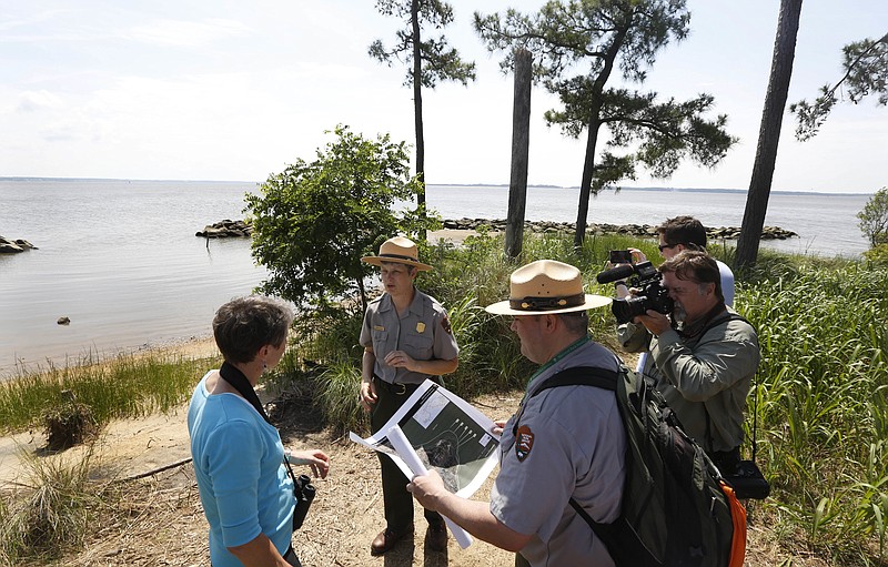 
              FILE This Thursday June 5, 2014 file photo shows former US Secretary of the Interior, Sally Jewell, left, as she listens to park service rangers during a tour of Jamestown Island in Jamestown, Va. A power company is getting set to build 17 transmission towers in Virginia near colonial Jamestown Island. And already the utility has begun paying out $90 million for projects to blunt the impact on significant historic areas.  (AP Photo/Steve Helber)
            