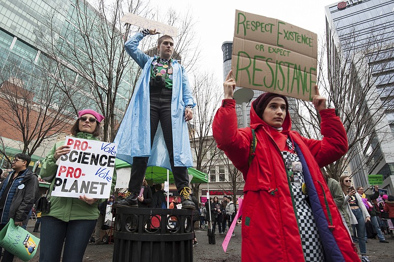 Jane Potter Baumer, left, her daughter, Frankie Baumer, center, and Shatha Alawwad, hold signs during a Women's March on Sunday, Jan. 21, 2018, in Pittsburgh. (Stephanie Strasburg/Pittsburgh Post-Gazette via AP)