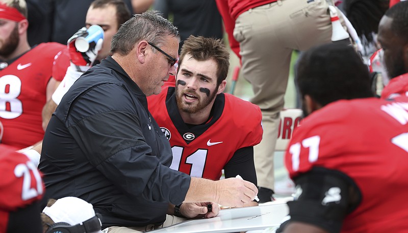 Georgia offensive line coach Sam Pittman visits with quarterback Jake Fromm (11) and his offensive linemen on the sideline during the 38-7 win at Georgia Tech on Nov. 25.