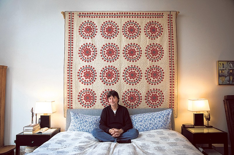 Ken Burns, the documentary filmmaker, sits below his favorite quilt on display in his apartment in New York. (Benjamin Norman/The New York Times)