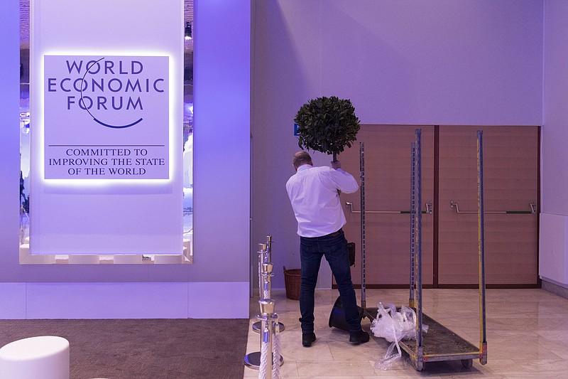 A worker places a plant during preparations for the 48th annual meeting of the World Economic Forum, WEF, in Davos, Switzerland, Sunday, Jan. 21, 2018. The meeting brings together entrepreneurs, scientists, chief executives and political leaders from Jan. 23 to 26. (Gian Ehrenzeller/Keystone via AP)
