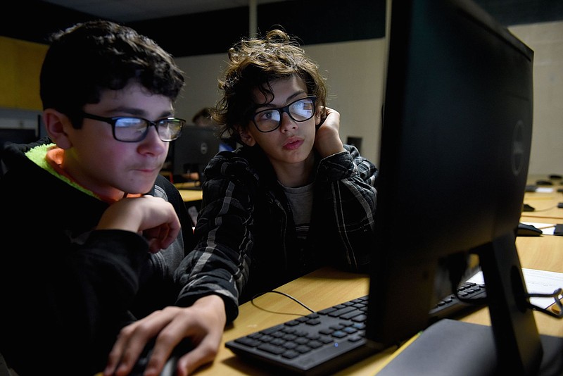 Xander Landrum, center, and David Savoy work together during coding class at Carter Middle School Thursday, Oct. 26, 2017. Knox County Schools is pushing to get more students coding and has developed a dedicated computer science curriculum.