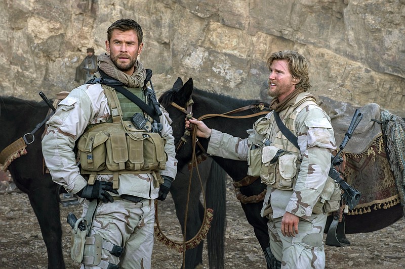 This image released by Warner Bros. Entertainment shows Chris Hemsworth, left, and Thad Luckinbill in a scene from "12 Strong." (David James/Warner Bros. Entertainment via AP)
