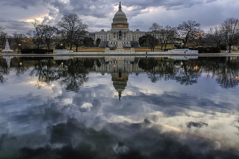Clouds are reflected in the U.S. Capitol reflecting pool at daybreak in Washington on Monday, Jan. 22, 2018. (AP Photo/J. David Ake)