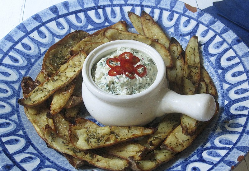 This Jan. 9 2018 photo shows potato skins baked with roasted garlic rosemary butter and an onion kale dip spiked with fresh chiles. This dish is from the recipe "Decadent Snacks for the Super Bowl" by Sara Moulton. (Sara Moulton via AP)